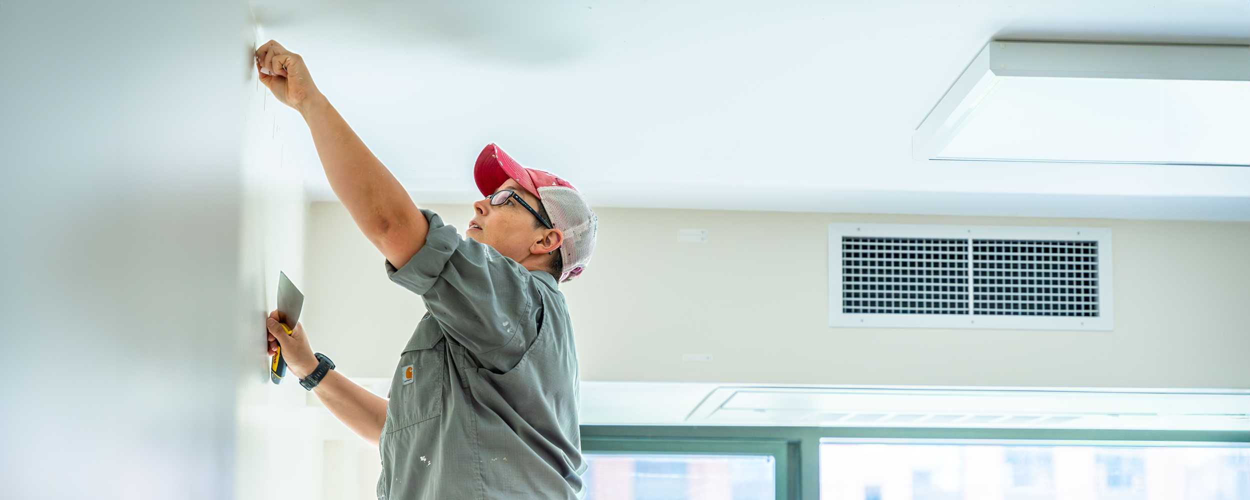 Facilities worker fixing a wall