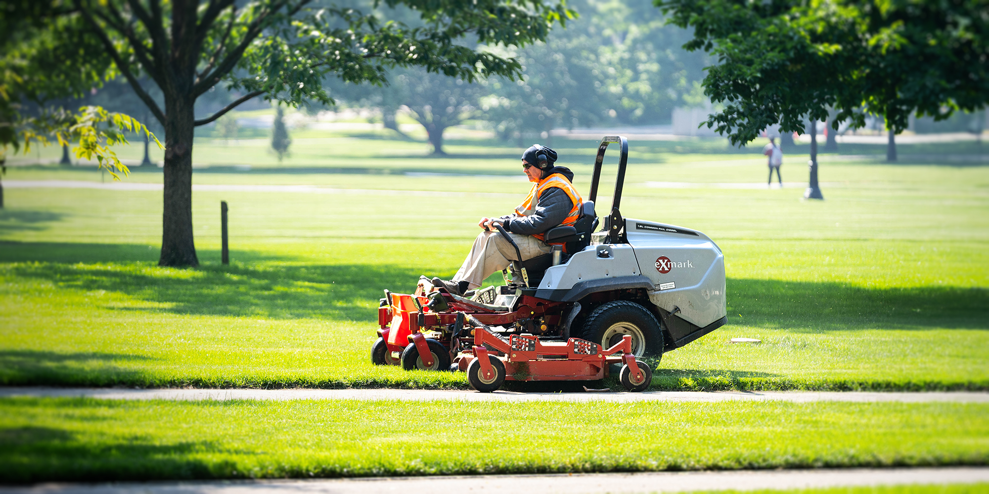 FOD operations staff on a riding mower on the oval