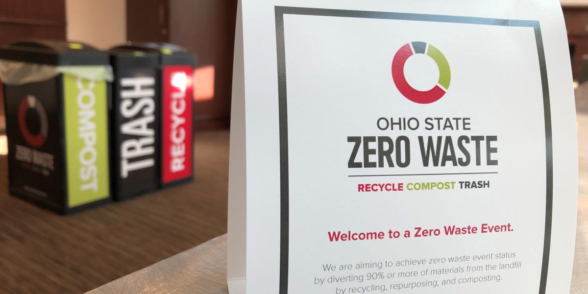 zero waste bins blurred in the background, with table placard in the foreground