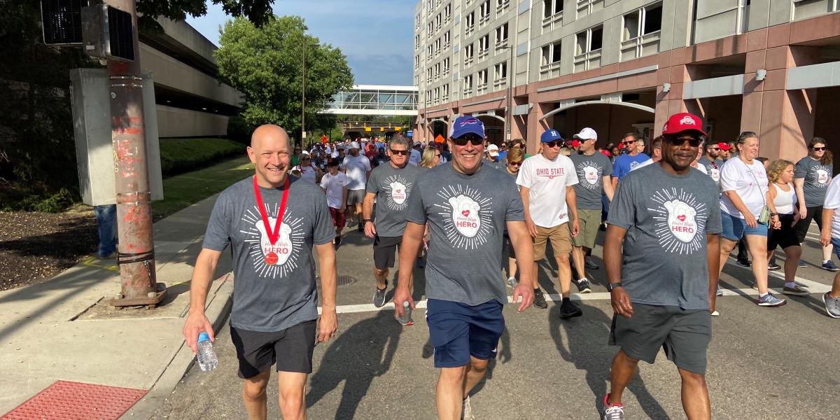 3 men walk amongst group