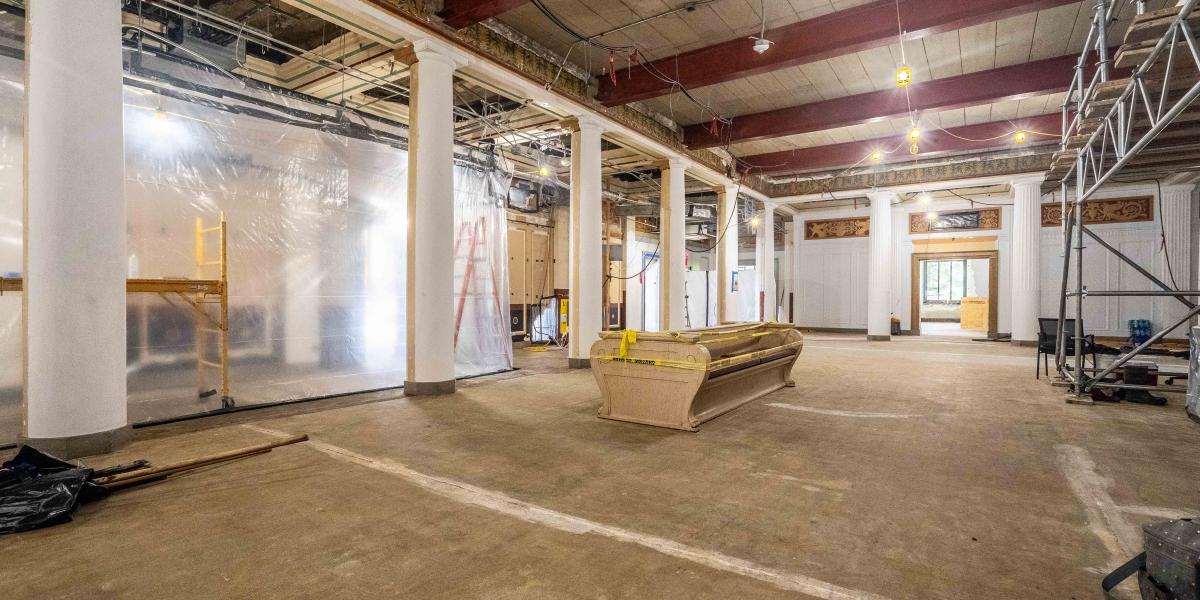 A view of the central common area where large white pillars can be seen along with unfinished floor.