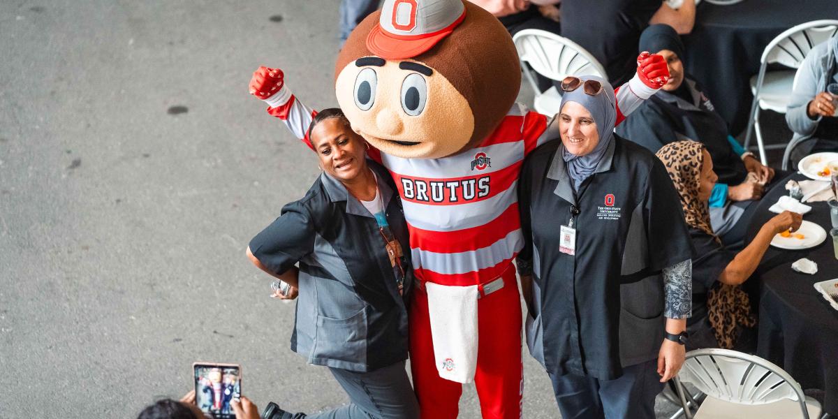 Brutus posing for a photo with two women.