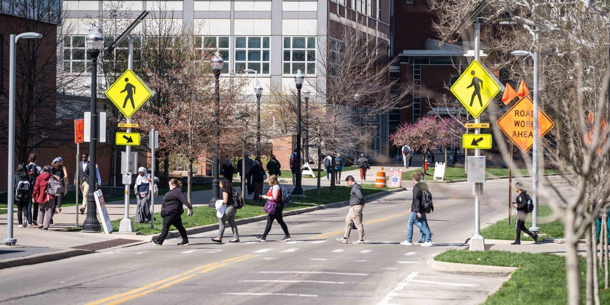 pedestrians walking through crosswalk near construction area