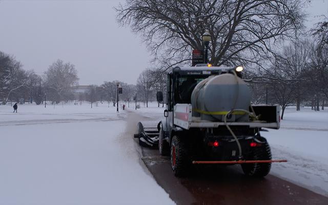 An FOD snow removal and pavement treatment vehicle on the oval removing snow.