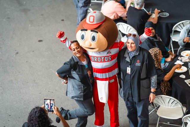 Brutus posing for a photo with two women.