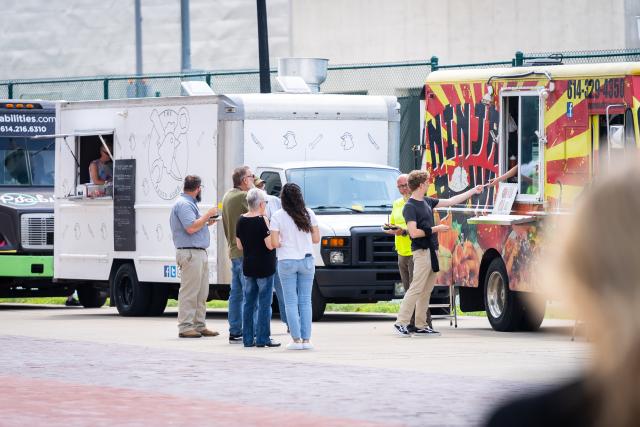 a group of people deciding what food truck to eat from
