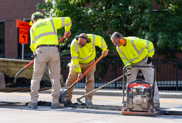 Facilities Operations and Development staff filling a pothole on campus