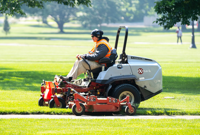 Facilities Operations and Development staff mowing along the oval