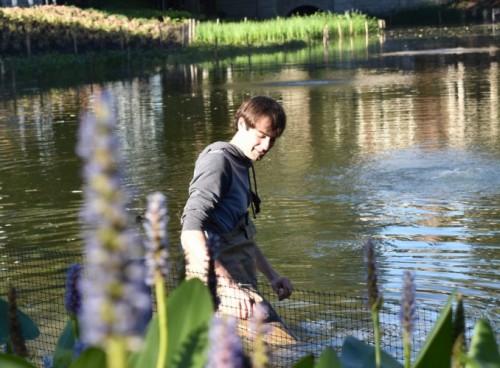 A man wearing waders in the water at Mirror Lake.