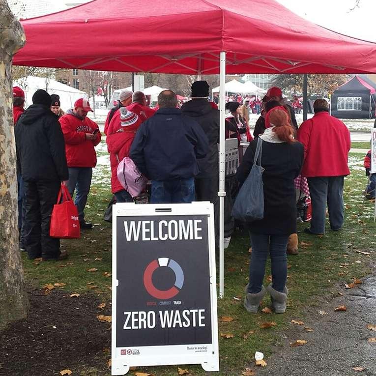 A zero waste a-frame sign outside of a tailgate tent on a football game day.