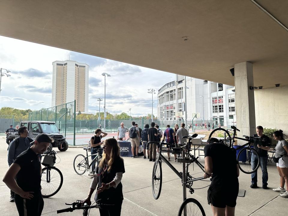 A view of the Buckeye Bike Hub with about 12 people with their bikes enjoying the event.