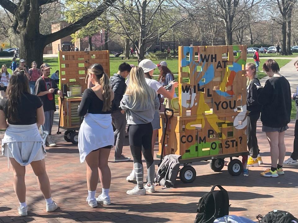students listening to presentatio on oval near wagons